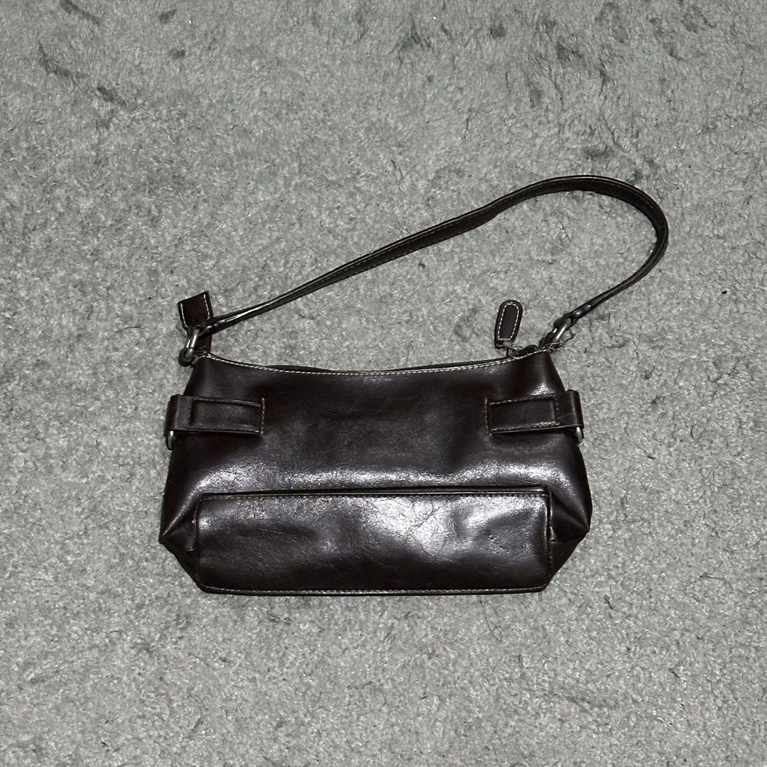 Nine West Brown Leather Shoulder Bag (Category: Shoulder Bags) located in Lipa City. Submitted by jecoparra (Listing ID 1465835790, Image 3). Description: - Brand: Nine West - Material: Dark brown faux leather with chic white contrast stitching - Hardware: Small silver-tone metal logo plate and buckle accents on sides - Straps: Comfortable double strap design - Closure: Secure top zipper closure - Interior: Clean lining, compact size ideal for da