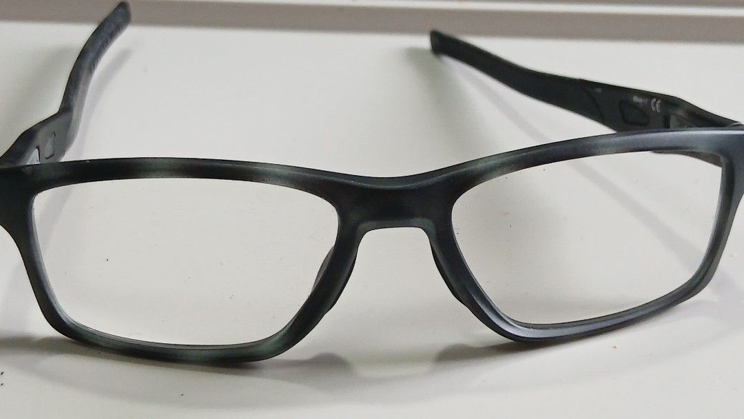 Oakley Eyeglasses Frame 55-17 (Category: Sunglasses & Eyewear) located in Cainta. Submitted by renped (Listing ID 1465800387, Image 3). Description: - Brand: Oakley Optical Frames - Color: Matte black and grey camouflage finish - Size: 55-17 (Temple length: 137mm) - Frame Shape: Modern rectangular with standard hinges - Material: Lightweight composite for all-day comfort - Lenses: Clear demonstration lenses (ready for your prescription lenses at 
