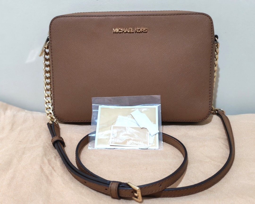[ORIGINAL] Michael Kors Jet Set Crossbody (Category: Cross-body Bags) located in Antipolo. Submitted by _mtoc7 (Listing ID 1465840981, Image 1). Description: - Brand: Michael Kors - Material: Saffiano leather - Hardware: Elegant gold-tone with chain strap details - Closure: Secure zip-top closure - Features: Structured rectangular shape with clean stitching - Condition: Likenew (used twice only) and well-maintained -Flaw is a tiny bit tarnishing 