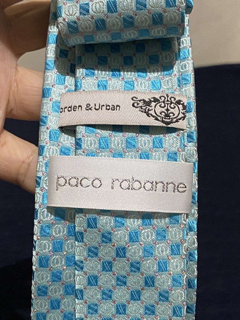 Paco Rabanne blue patterned silk necktie (Category: Ties) located in Manila. Submitted by resi.diaz (Listing ID 1465871977, Image 3). Description: - Material: 100% pure silk with silver woven background threads for a subtle shine - Design: Light blue with a checkered geometric pattern and small pink dot accents - Fit: Standard width, ideal for formal wear, business meetings, and office attire - Details: Authentic brand labels stitched on the back