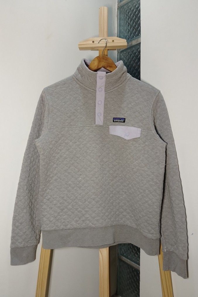 Patagonia Quilted Snap-T Pullover (Category: Coats, Jackets and Outerwear) located in Manila. Submitted by patrickjos06722 (Listing ID 1465904692, Image 1). Description: - Brand: Patagonia - Style: Quilted pullover sweater - Color: Grey with light purple snap button placket, chest pocket, and classic logo patch - Details: Ribbed cuffs and hem - Width: ~20 inches - Length: ~24 inches - Condition: Great pre-loved condition (Trusted Carousell Seller