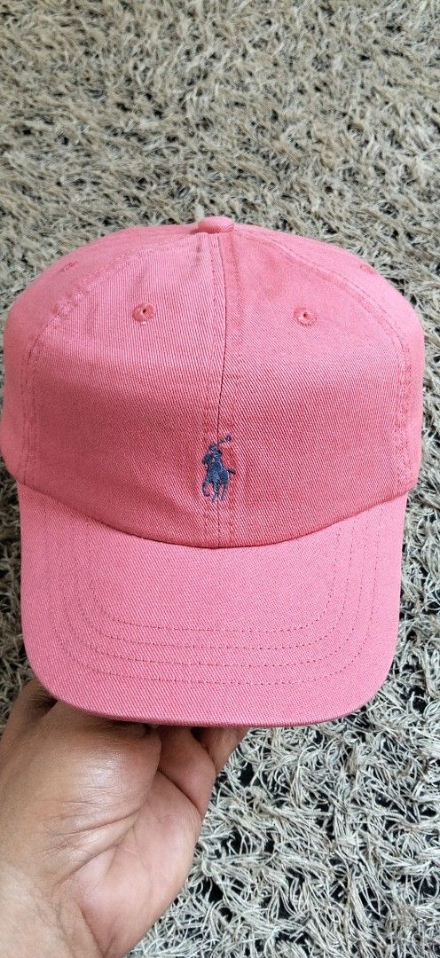 Polo Ralph Lauren Pink Baseball Cap AUTHENTIC (Category: Activewear) located in Paranaque City. Submitted by michael-08 (Listing ID 1465886920, Image 1). Description: - Brand: Polo Ralph Lauren - Color: Pink with blue accents - Design: Classic six-panel construction with embroidered eyelets - Details: Embroidered blue pony logo on the front and "POLO" embroidery on the back - Fit: Adjustable strap with a metal buckle slider for a custom fit - Con