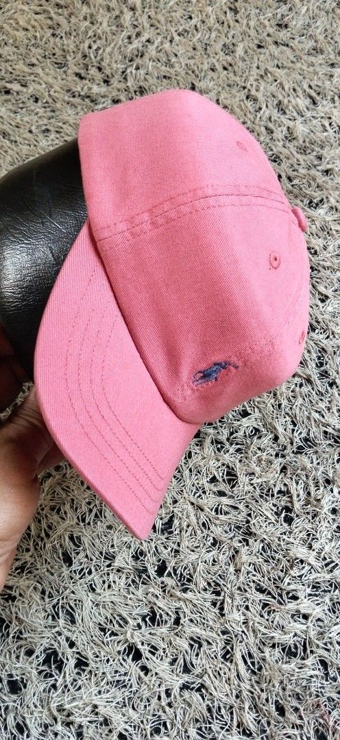 Polo Ralph Lauren Pink Baseball Cap AUTHENTIC (Category: Activewear) located in Paranaque City. Submitted by michael-08 (Listing ID 1465886920, Image 2). Description: - Brand: Polo Ralph Lauren - Color: Pink with blue accents - Design: Classic six-panel construction with embroidered eyelets - Details: Embroidered blue pony logo on the front and "POLO" embroidery on the back - Fit: Adjustable strap with a metal buckle slider for a custom fit - Con
