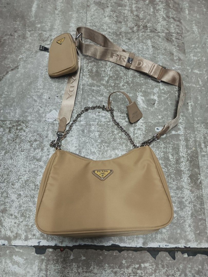 Prada Beige Nylon Re-Edition Shoulder Bag with Chain (Category: Luxury Bags & Wallets) located in Baguio. Submitted by brandeditems16 (Listing ID 1465945552, Image 1). Description: - Authentic Prada nylon shoulder bag in classic beige - Silver-tone hardware and top zip closure - Includes two interchangeable straps: thick branded strap and elegant chain strap - Comes with a small detachable pouch for extra functionality - Interior lined with signa