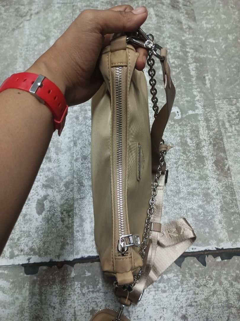 Prada Beige Nylon Re-Edition Shoulder Bag with Chain (Category: Luxury Bags & Wallets) located in Baguio. Submitted by brandeditems16 (Listing ID 1465945552, Image 3). Description: - Authentic Prada nylon shoulder bag in classic beige - Silver-tone hardware and top zip closure - Includes two interchangeable straps: thick branded strap and elegant chain strap - Comes with a small detachable pouch for extra functionality - Interior lined with signa