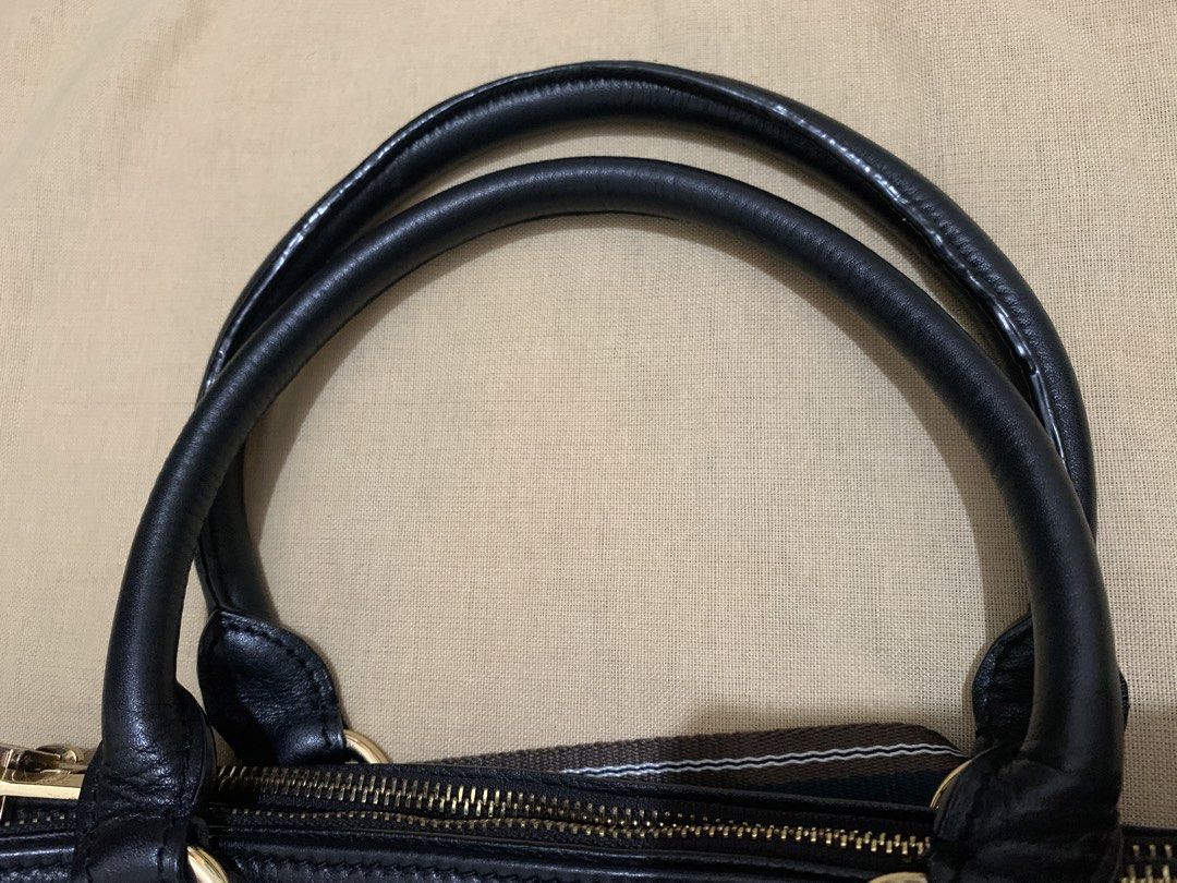 Prada Black Leather Handbag with Striped Strap (Category: Luxury Bags & Wallets) located in Marikina City. Submitted by sundaysantos (Listing ID 1465773374, Image 1). Description: - Authentic Prada handbag in black textured leather - Elegant gold hardware with Prada Milano logo and stamped zippers - Dual top handles and a stylish detachable striped shoulder strap - Interior features black logo fabric lining, multiple slip pockets, and a middle zi