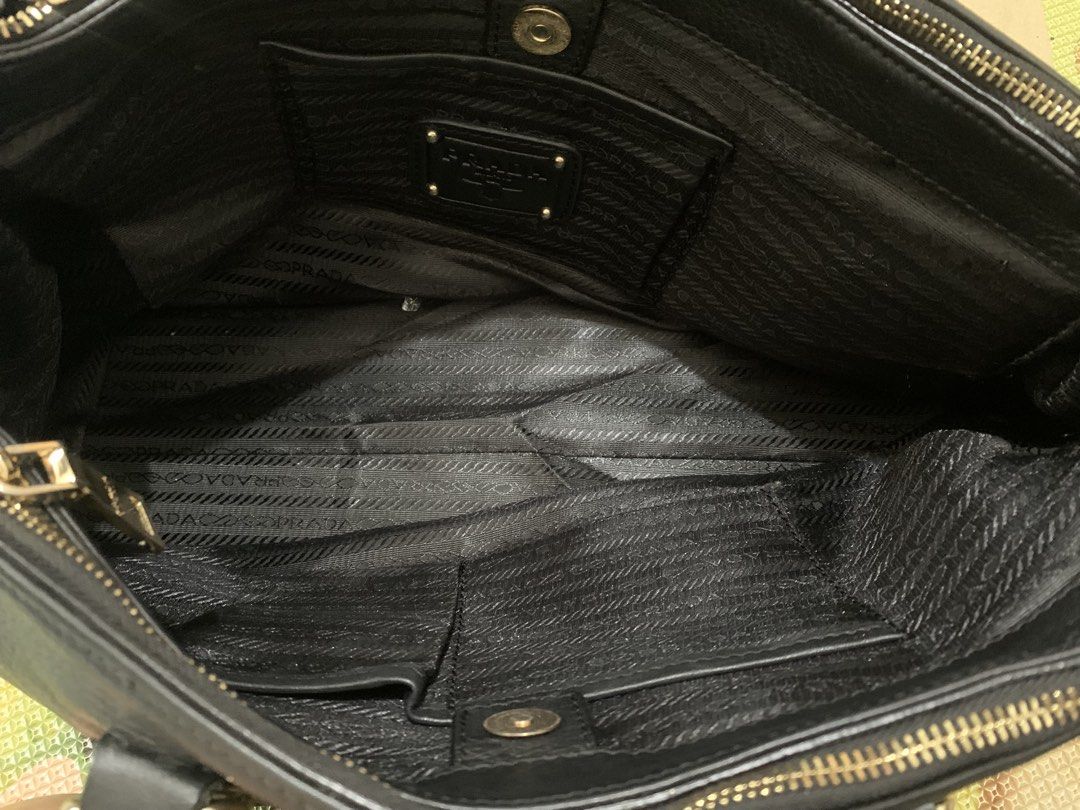 Prada Black Leather Handbag with Striped Strap (Category: Luxury Bags & Wallets) located in Marikina City. Submitted by sundaysantos (Listing ID 1465773374, Image 3). Description: - Authentic Prada handbag in black textured leather - Elegant gold hardware with Prada Milano logo and stamped zippers - Dual top handles and a stylish detachable striped shoulder strap - Interior features black logo fabric lining, multiple slip pockets, and a middle zi