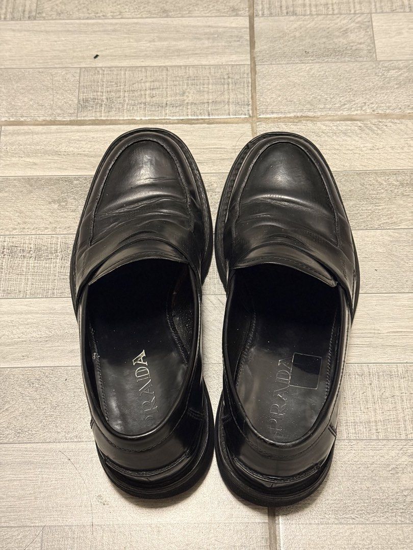 Prada Black Leather Penny Loafers (Category: Dress Shoes) located in Manila. Submitted by c_archive (Listing ID 1465896598, Image 2). Description: Prada black leather penny loafers. Natural creasing across the leather vamp from regular wear. Outsole re-stitched in Mr. Quickie.