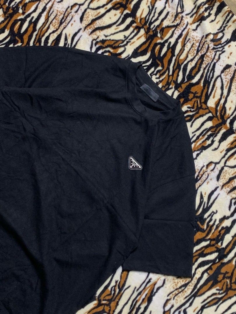 Prada Black T-Shirt with Triangle Logo (Category: Shirts) located in San Juan City. Submitted by findmorelux (Listing ID 1465858937, Image 2). Description: - Brand: Prada - Color: Classic Black - Fit: Relaxed fit with short sleeves - Material: Clean cotton jersey knit - Detail: Iconic enamel triangle logo badge on left chest - Condition: Great casual basic piece for everyday wear.