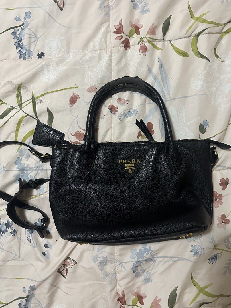 Prada Vitello Daino Small Tote (Category: Luxury Bags & Wallets) located in Makati City. Submitted by biancak20 (Listing ID 1465897347, Image 1). Description: - Brand: Prada - Material: crafted from textured calfskin leather with gold-tone hardware and dual top handles. - Features: Dual top handles, adjustable shoulder strap, signature front lettering logo, 4 protective metal feet - Interior: Black fabric lining with a secure zip compartment - Co