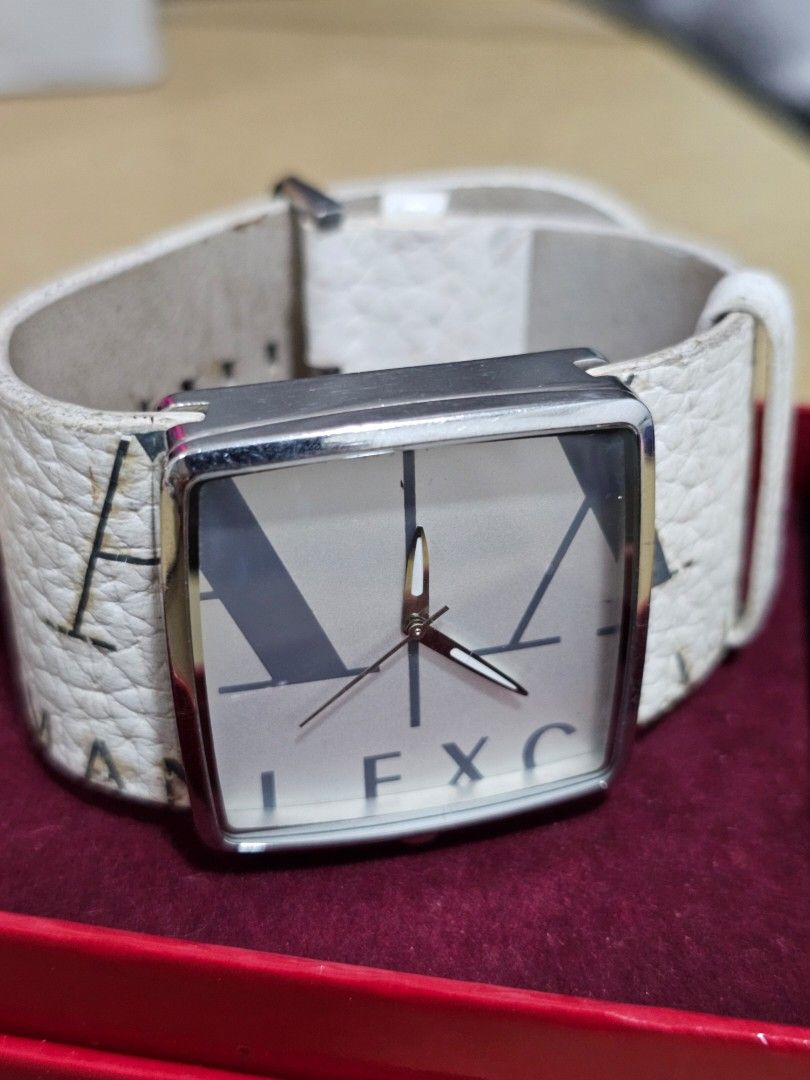 Pre-loved Armani Exchange Square Face Watch White Leather Strap (Category: Women's Watches) located in Caloocan City. Submitted by smart_shoppers_ville (Listing ID 1465761864, Image 2). Description: - Brand: Armani Exchange - Design: Square silver-tone metal case with a minimalist analog dial and geometric markers - Strap: White textured leather strap with large graphic branding and silver-tone buckle - Movement: Battery-powered quartz movement f