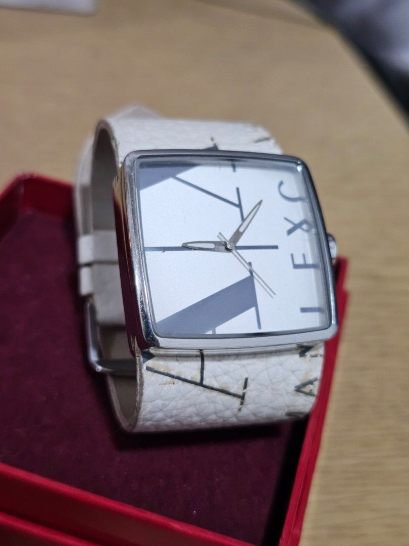 Pre-loved Armani Exchange Square Face Watch White Leather Strap (Category: Women's Watches) located in Caloocan City. Submitted by smart_shoppers_ville (Listing ID 1465761864, Image 1). Description: - Brand: Armani Exchange - Design: Square silver-tone metal case with a minimalist analog dial and geometric markers - Strap: White textured leather strap with large graphic branding and silver-tone buckle - Movement: Battery-powered quartz movement f