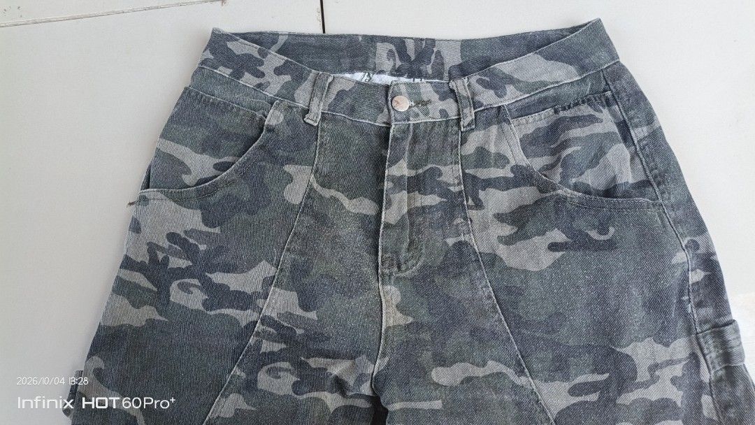 Random Camouflage Cargo Jeans Pants (Category: Jeans) located in Manila. Submitted by treblig. (Listing ID 1465813665, Image 3). Description: - Brand: Renben - Pattern: Green and grey camouflage - Material: Thick, durable denim-like fabric - Fit: Mid-rise waist with straight-leg cut - Closure: Button and zip fly - Details: Unique front panel stitching, utility loop - Pockets: Two deep back pockets - Branding: Stitched brand tag on back waistband.