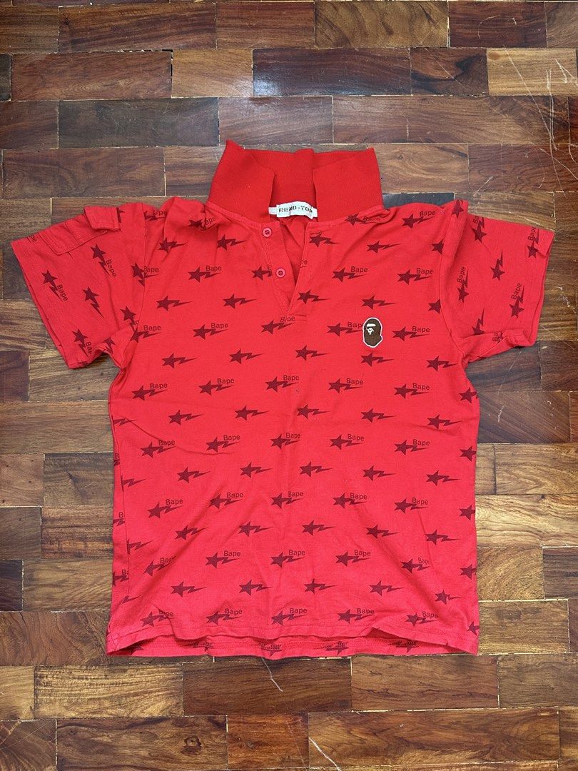 Red Bape Star Print Polo Shirt (Category: Tshirts & Polo Shirts ) located in Cainta. Submitted by buy.preloved (Listing ID 1465768477, Image 1). Description: - Color: Bright red with dark red star and Bape text all-over pattern - Details: Small embroidered ape head patch on the chest - Features: Short sleeves with a small flap pocket on one arm, red buttoned collar - Brand/Tag: Rend-Top collar tag - Condition: Pre-loved, great statement piece.