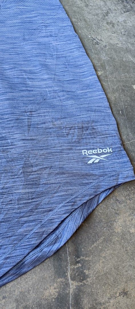 Reebok Workout Racerback Tank Top Blue Size M (Category: Activewear) located in Manila. Submitted by sandobag (Listing ID 1465817259, Image 2). Description: - Size: W 17.5 L 27.5 - Excellent condition - Color rate: 10/10 - Brand: Reebok - Item: Athletic tank top - Color: Heather blue - Size: Medium (M) - Design: Racerback style with curved hem and small white logo - Material: Lightweight, ideal for workouts and running - Condition: Clean and well