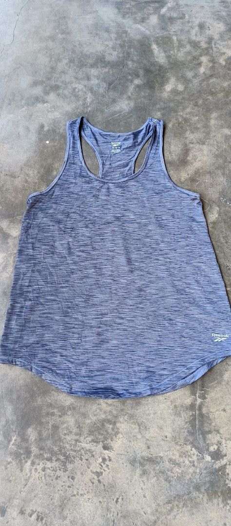 Reebok Workout Racerback Tank Top Blue Size M (Category: Activewear) located in Manila. Submitted by sandobag (Listing ID 1465817259, Image 1). Description: - Size: W 17.5 L 27.5 - Excellent condition - Color rate: 10/10 - Brand: Reebok - Item: Athletic tank top - Color: Heather blue - Size: Medium (M) - Design: Racerback style with curved hem and small white logo - Material: Lightweight, ideal for workouts and running - Condition: Clean and well