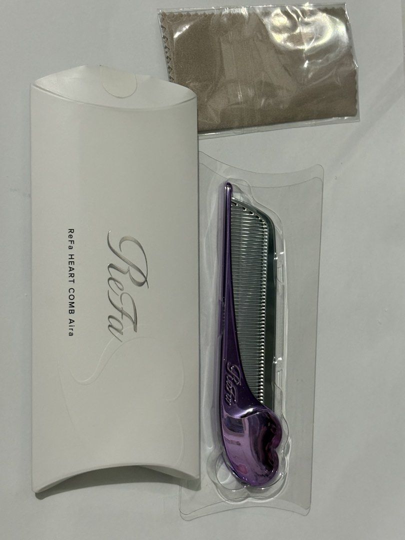 ReFa HEART COMB Aira M Purple (Category: Hair Accessories) located in General Trias. Submitted by perikok0 (Listing ID 1465829608, Image 3). Description: - Model: ReFa Heart Comb Aira in M Purple - Design: Cute heart-shaped handle with a stylish metallic finish - Benefits: Keeps hair smooth, shiny, and tangle-free - Portability: Compact size, easily fits in any handbag for on-the-go touch-ups - Inclusions: Comes with original white packaging box 