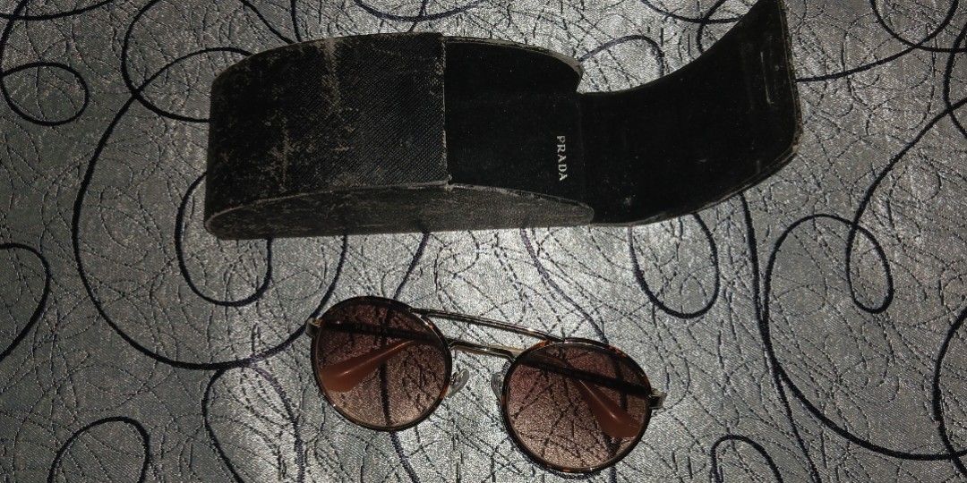 Round Tortoiseshell Sunglasses With Case (Category: Sunglasses & Eyewear) located in Taguig. Submitted by trade_fairly (Listing ID 1465918628, Image 1). Description: - Style: Round tortoiseshell frames with gradient lenses - Detail: Metal double bridge across the top - Fit & Comfort: Comfortable everyday wear, blocks glare effectively - Inclusion: Comes with a black hard case (note: slight wear on the case surface) - Old Prada Sunglasses some scr