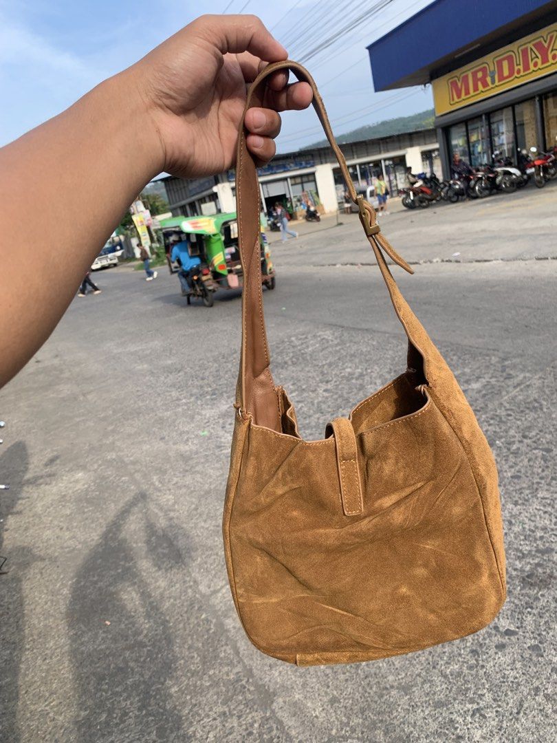 Saint Laurent Brown Suede Shoulder Bag (Category: Luxury Bags & Wallets) located in Gingoog City. Submitted by pureshark-307a (Listing ID 1465841023, Image 2). Description: - Brand: Saint Laurent (YSL) - Material: Premium brown suede with gold-tone hardware - Design: Signature interlocking YSL logo on the front with a soft, slouchy open-top shape - Strap: Adjustable buckle strap with engraved branding - Size: Perfect everyday bag to easily hold a