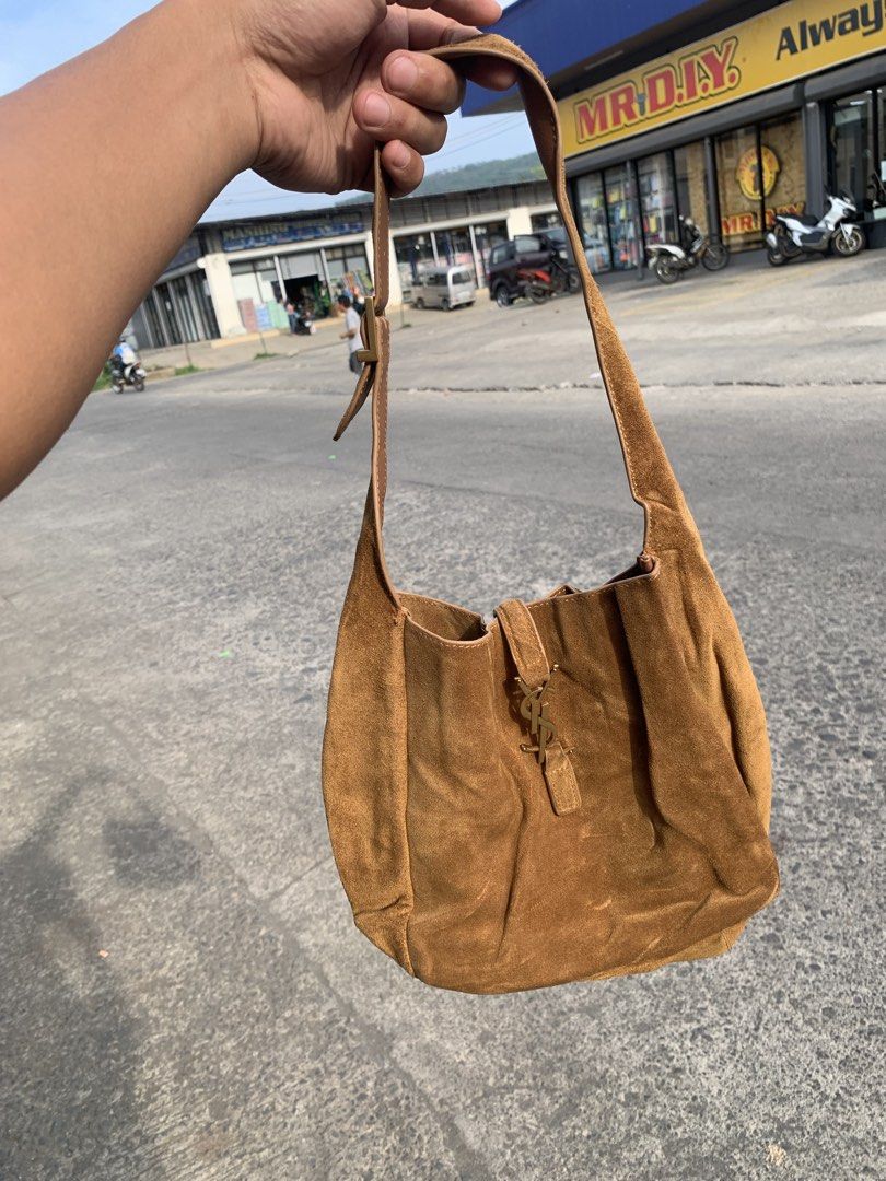 Saint Laurent Brown Suede Shoulder Bag (Category: Luxury Bags & Wallets) located in Gingoog City. Submitted by pureshark-307a (Listing ID 1465841023, Image 1). Description: - Brand: Saint Laurent (YSL) - Material: Premium brown suede with gold-tone hardware - Design: Signature interlocking YSL logo on the front with a soft, slouchy open-top shape - Strap: Adjustable buckle strap with engraved branding - Size: Perfect everyday bag to easily hold a
