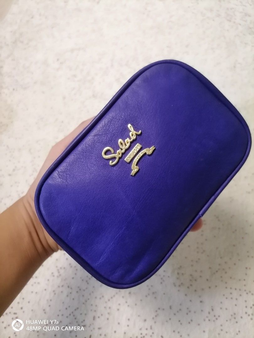 Salad blue leather cosmetic pouch (Category: Purses & Pouches) located in Naga. Submitted by mrwisethrifter (Listing ID 1465829596, Image 1). Description: - Brand: Salad - Color: Electric blue - Material: Smooth leather-feel finish - Hardware: Gold-tone with front logo and ribbon emblem - Closure: Fully zipped top - Use: Compact size, ideal for makeup or small daily essentials.