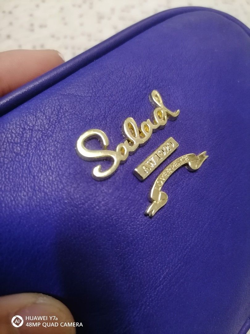 Salad blue leather cosmetic pouch (Category: Purses & Pouches) located in Naga. Submitted by mrwisethrifter (Listing ID 1465829596, Image 2). Description: - Brand: Salad - Color: Electric blue - Material: Smooth leather-feel finish - Hardware: Gold-tone with front logo and ribbon emblem - Closure: Fully zipped top - Use: Compact size, ideal for makeup or small daily essentials.