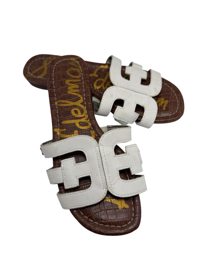 Sam Edelman (Category: Sneakers & Footwear) located in Baguio. Submitted by jerome09965737 (Listing ID 1465950328, Image 2). Description: - Brand: Sam Edelman - Style: Slip-on slide sandals - Color/Material: White leather cut-out straps with brown croc-embossed footbed - Details: Gold logo print on footbed, flat sole with textured tread - Condition: Normal wear on straps and soles, plenty of life left - Perfect for: Quick, stylish warm-weather ou
