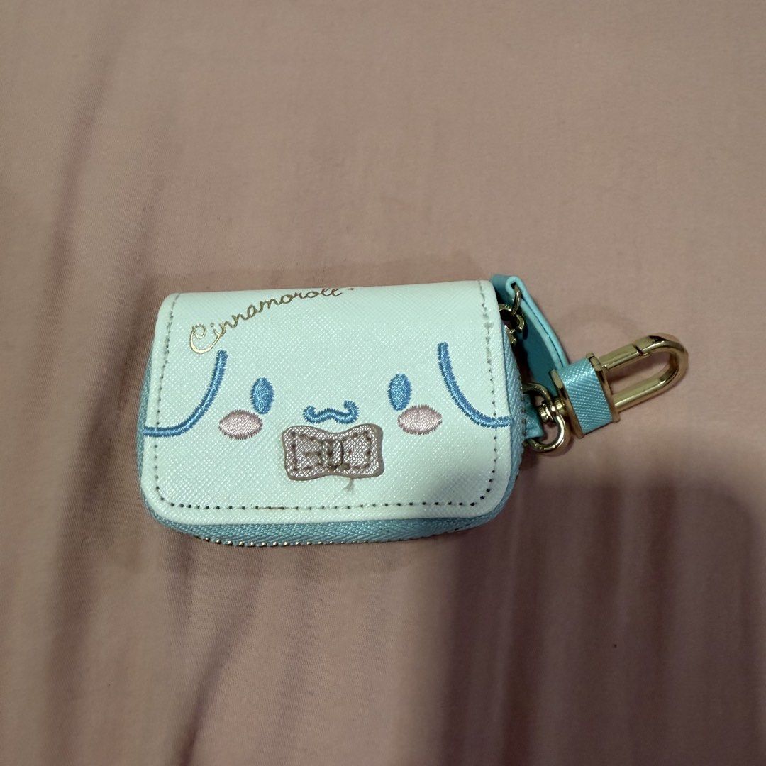 Sanrio Cinnamoroll Mini Key Case Pouch Blue White (Category: Character Goods) located in Caloocan City. Submitted by preloveditemsbyyana (Listing ID 1465934846, Image 1). Description: - Authentic Sanrio Cinnamoroll mini key case in light blue and white - Features adorable embroidered character face with a pink bow and logo - Cute swirl embroidery detail on the back - Secure gold-toned zipper closure with attached hardware clip - Clean interior li