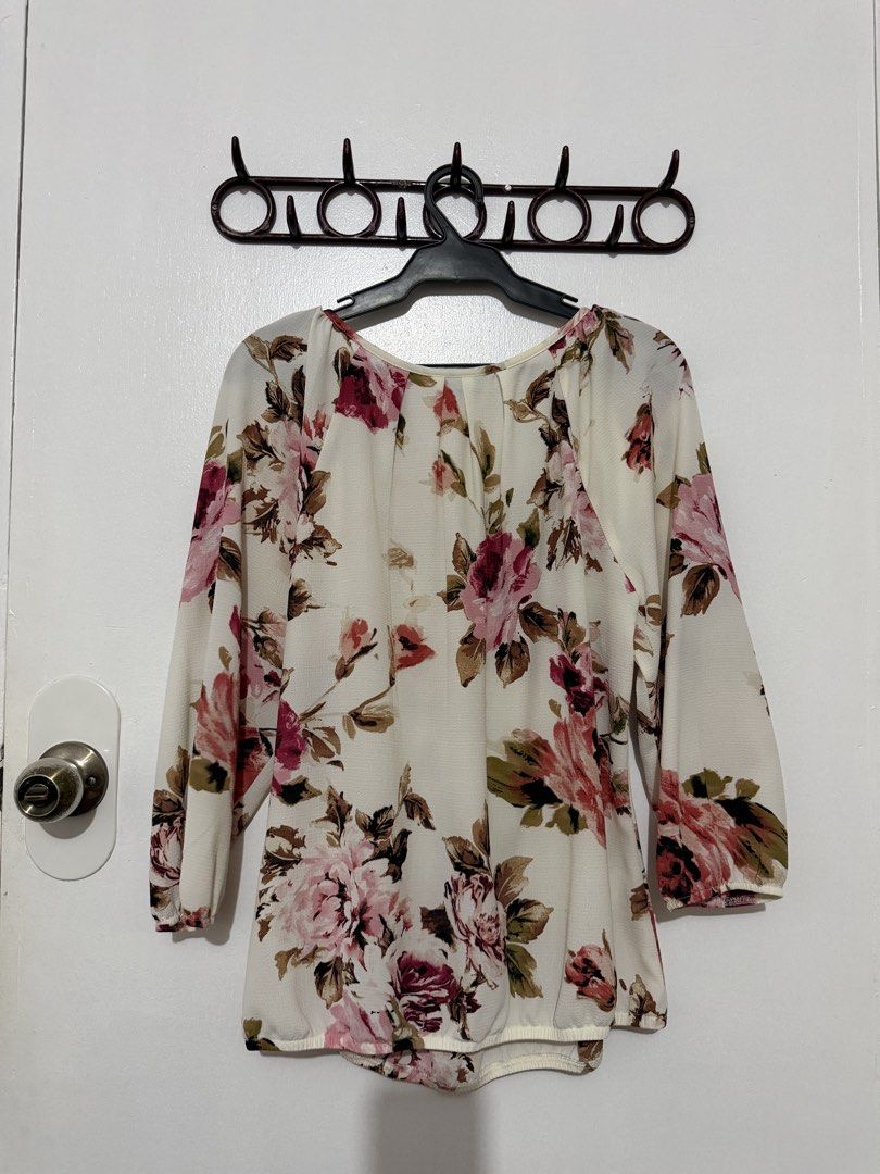 Sara Michelle Floral Print Blouse Medium (Category: Blouses) located in Las Pinas. Submitted by milkydeclutter (Listing ID 1465939718, Image 3). Description: - Brand: Sara Michelle - Size: Medium (tag attached) - Color/Pattern: Cream base with pink and red floral print - Features: Long sleeves with gathered cuffs, subtle neckline pleating - Material: Lightweight fabric, ideal for layering or solo wear - Condition: Excellent.