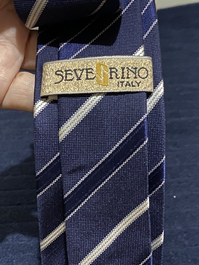 Severino Italy 100% Silk Striped Tie (Category: Ties) located in Manila. Submitted by resi.diaz (Listing ID 1465856607, Image 2). Description: - Brand: Severino (Made in Italy) - Material: 100% pure silk with smooth textured finish - Design: Classic navy blue with diagonal white and blue stripes - Size: Standard width necktie - Condition: Excellent, clean fabric with no stains or loose threads - Ideal for: Business meetings, formal events, and of