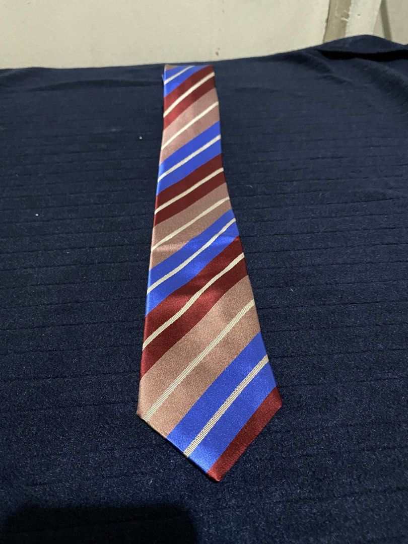 Severino Italy 100% Silk Striped Tie (Category: Ties) located in Manila. Submitted by resi.diaz (Listing ID 1465896004, Image 1). Description: - Brand: Severino Italy - Material: 100% Silk with a smooth finish - Design: Vibrant striped pattern in blue, maroon, and brown with thin white accents - Size: Standard width and length - Versatility: Perfect for business casual, office wear, and formal events.