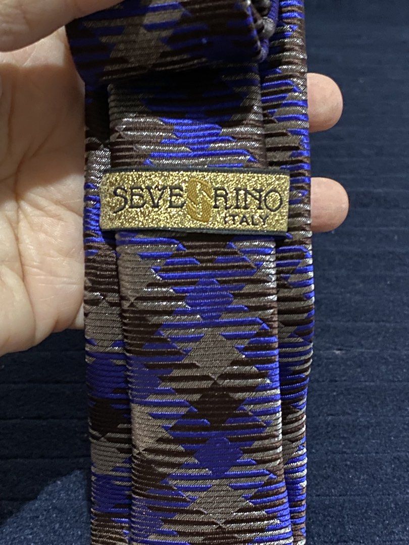 Severino Italy Silk Necktie Blue Brown Pattern (Category: Ties) located in Manila. Submitted by resi.diaz (Listing ID 1465860663, Image 3). Description: - Brand: Severino Italy - Material: 100% pure silk with a rich sheen and textured fabric - Design: Striking blue and brown geometric pattern - Fit: Standard width and length - Condition: Clean labels intact on the back - Style Tip: Great piece to add some color to your suit.