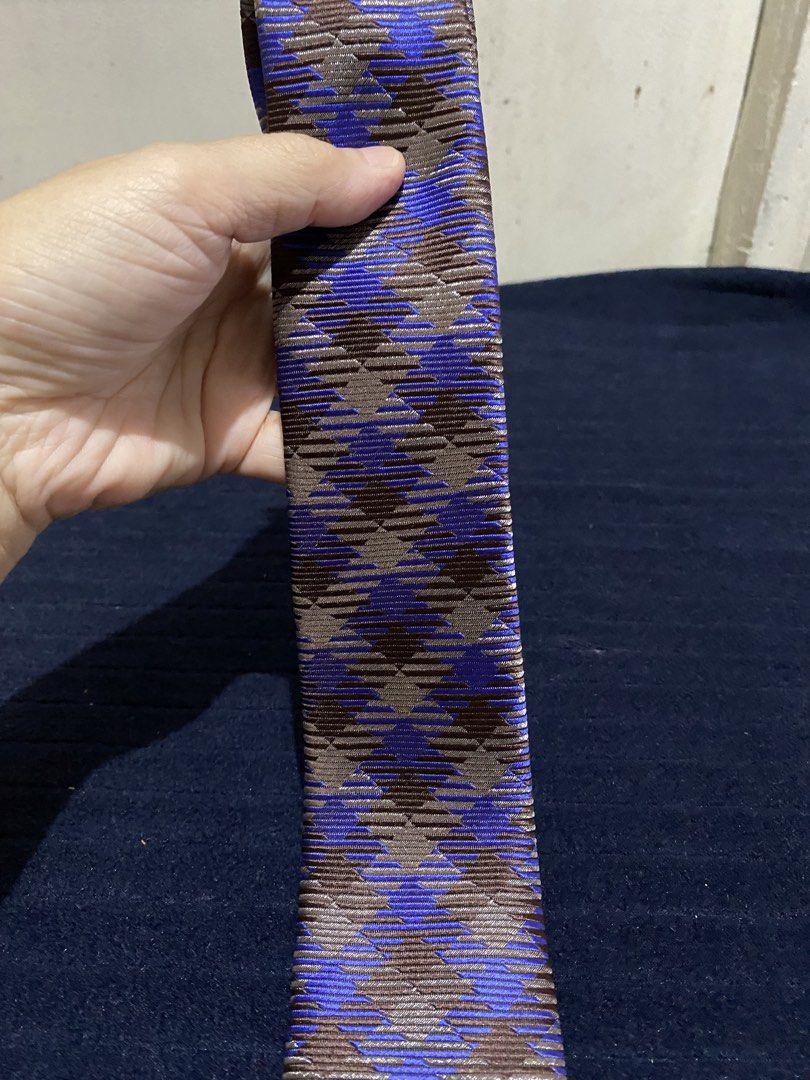 Severino Italy Silk Necktie Blue Brown Pattern (Category: Ties) located in Manila. Submitted by resi.diaz (Listing ID 1465860663, Image 2). Description: - Brand: Severino Italy - Material: 100% pure silk with a rich sheen and textured fabric - Design: Striking blue and brown geometric pattern - Fit: Standard width and length - Condition: Clean labels intact on the back - Style Tip: Great piece to add some color to your suit.