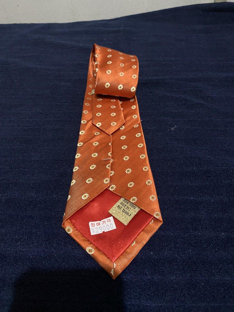 Severino Italy Silk Orange Necktie with Pattern (Category: Ties) located in Manila. Submitted by resi.diaz (Listing ID 1465836480, Image 2). Description: - Brand: Severino Italy - Material: 100% pure silk with a smooth texture and rich sheen - Design: Elegant orange base with a repeating gold and white geometric medallion pattern - Fit: Standard width silhouette, ideal for business attire and formal events - Condition: Brand new with original pri