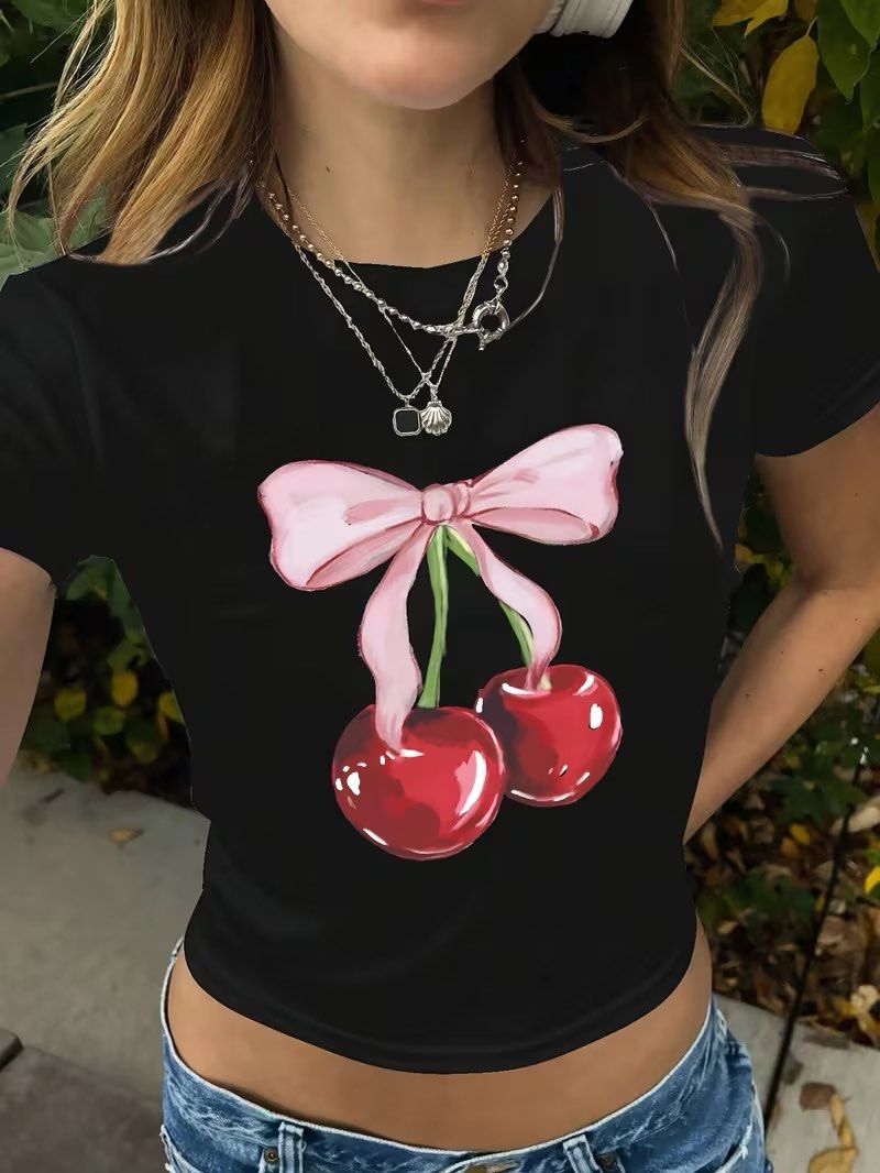 SHEIN Black Cherry Bow Graphic T-Shirt (Category: Shirts) located in Manila. Submitted by dianafayesimbre (Listing ID 1465831415, Image 1). Description: - Brand/Source: SHEIN - Size: Kids 12Y on tag but can fit small to semi large womens - Design: Pink bow and cherry graphic on front, solid black back - Cut: Short sleeves, round neckline - Condition: Brand new.