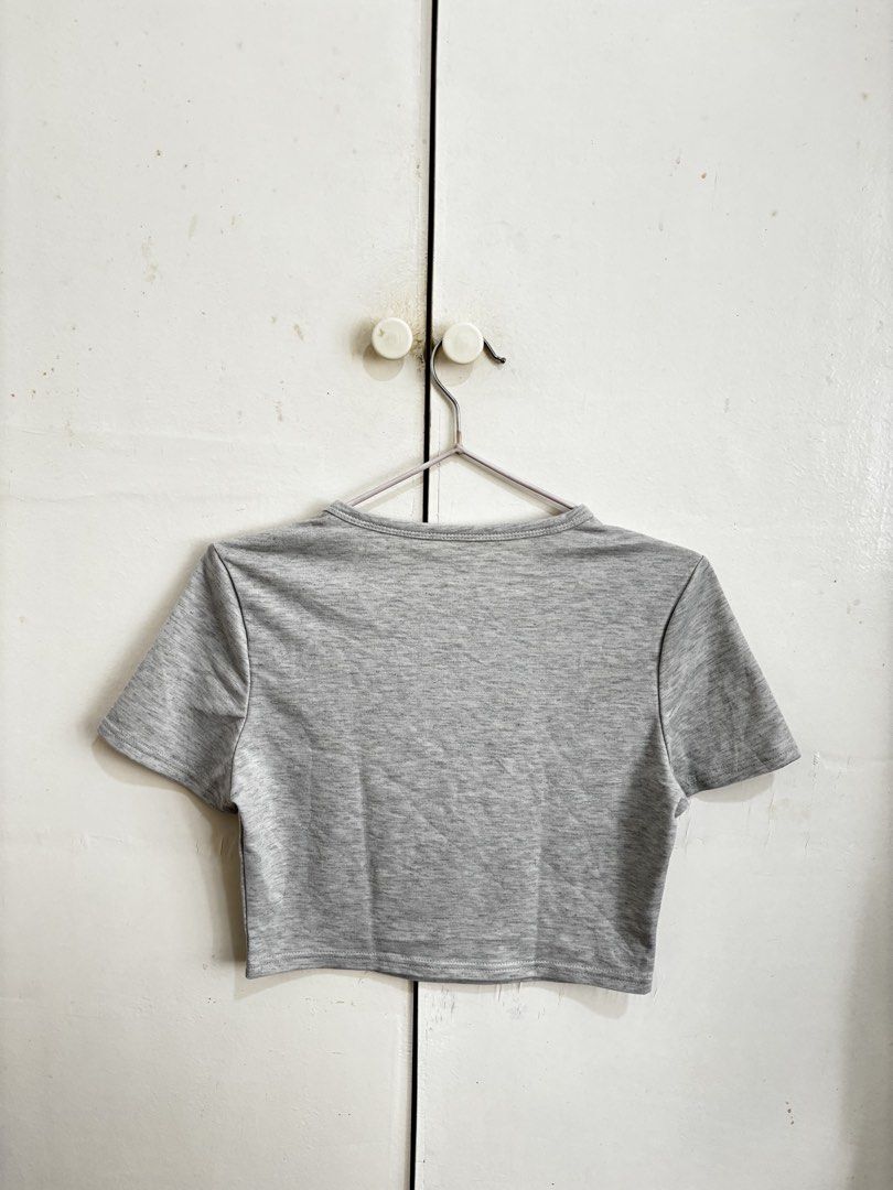 Shein Gray Cropped Shirt (Category: Shirts) located in Manila. Submitted by dianafayesimbre (Listing ID 1465841312, Image 3). Description: - Colour: Grey with black hand-drawn heart print - Style: Short-sleeve crop top with round neckline and straight hem - Material: Soft and stretchy fabric for all-day comfort - Fit: Perfect for casual outfits, pairs easily with high-waisted jeans or skirts - Condition: Brand new - Best fits xxs to medium frame.