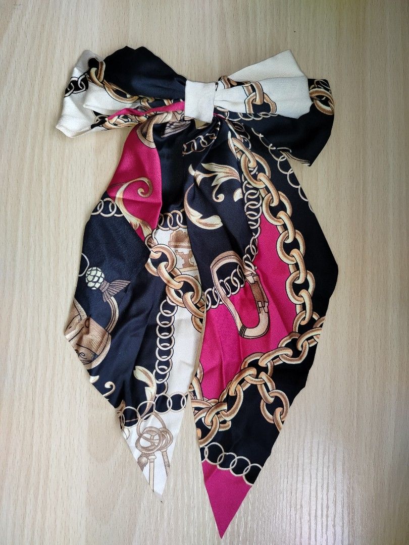 Silk hair bow clip chain print scarf pattern (Category: Hair Accessories) located in Rizal. Submitted by etcthings (Listing ID 1465870956, Image 1). Description: - Design: Silk scarf pattern with a trendy gold chain print in black, white, and hot pink - Hardware: Features a secure metal alligator clip stamped with 'OF HAND MADE' - Size: Medium, ideal for half-up hairstyles or ponytails - Texture: Smooth and premium fabric.
