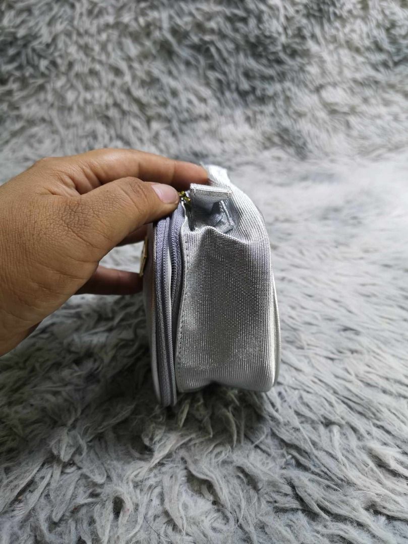 Silver Colored Metallic Finish Cosmetic Pouch (Category: Purses & Pouches) located in Santa Cruz. Submitted by jmy_surplus.2 (Listing ID 1465885648, Image 2). Description: Size ; L - 4.1 W - 6.6 Color ; Silver Type ; Pouch Brand ; No brand Material ; Synthetic Style ; Silver Zip Around With Top handle Cosmetic pouch LR 129 JMY 5 Batch #224.