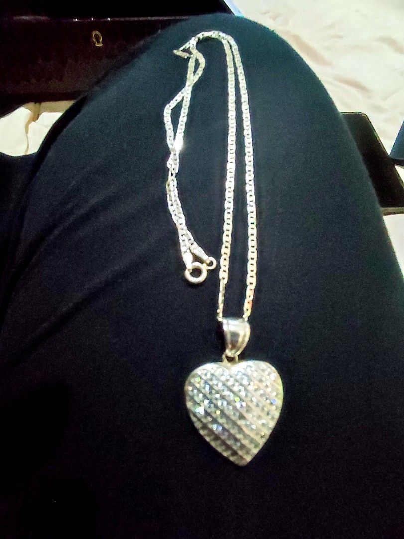 Silver Heart Pendant w/ Stones Necklace (Category: Necklaces) located in Cavite. Submitted by noblepenguin_6c8662 (Listing ID 1465886085, Image 3). Description: - 18 inch Silver 925 standard link chain necklace - Textured heart-shaped pendant with diagonal stripes - Covered in sparkling zirconia stones - Secure spring ring clasp closure - Features visible 925 hallmark stamps near the clasp.