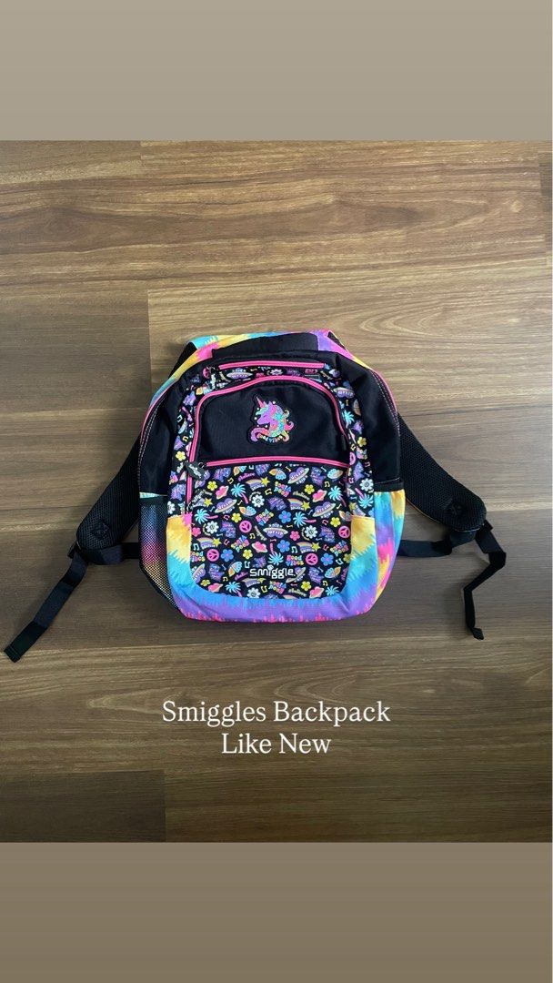 Smiggle Unicorn Multi-Colored Backpack (Category: Backpacks) located in Bacolod City. Submitted by jmcercado (Listing ID 1465925820, Image 1). Description: - Brand: Smiggle - Design: Black base with vibrant rainbow tie-dye, flowers, peace signs, and music notes - Details: Cute stitched unicorn patch on the front with eye-catching bright pink zippers - Storage: Spacious main compartment, front pocket, and dual mesh side pockets for water bottles -