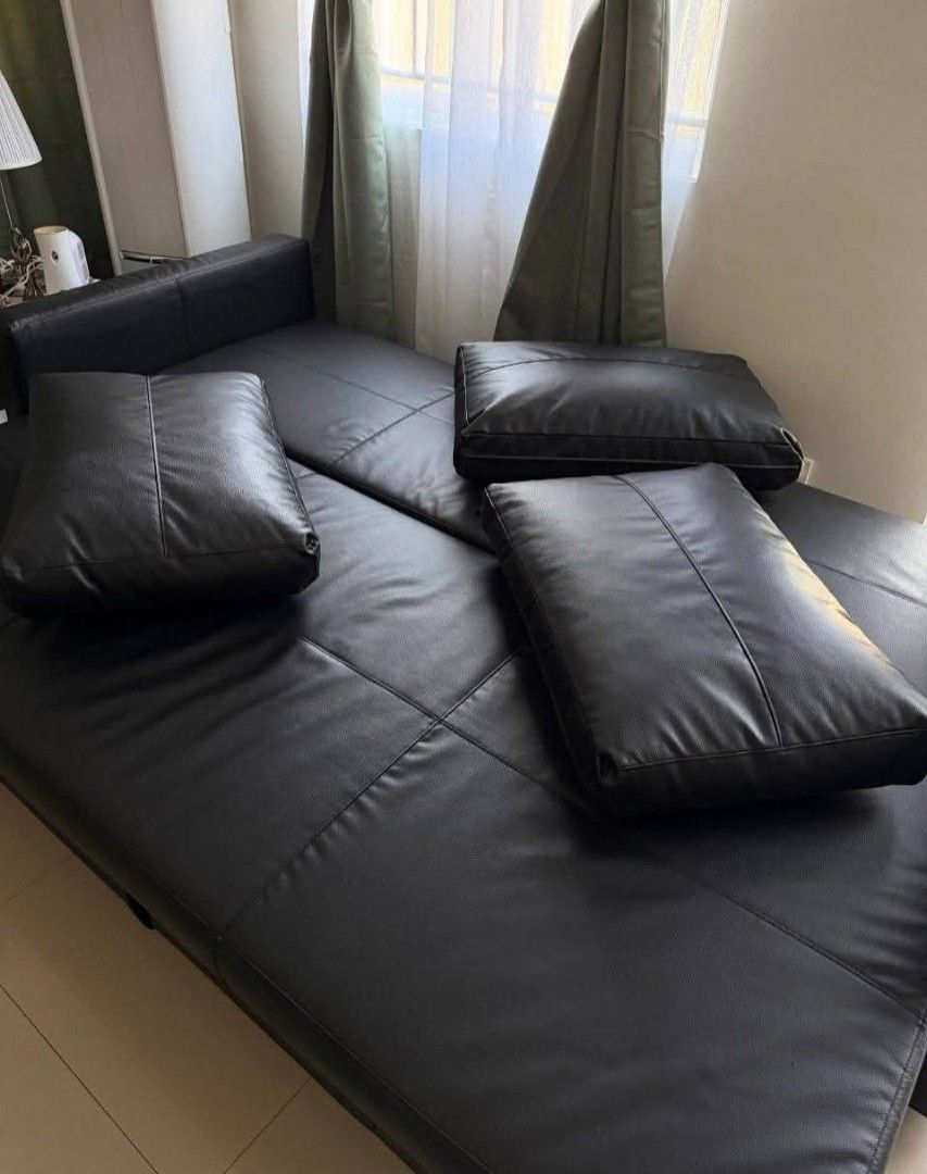 Sofa bed from IKEA (Category: Other Home Furniture) located in Taytay. Submitted by grace.bautista661 (Listing ID 1465771918, Image 2). Description: Moving out sale IKEA Sofa Bed with storage -Excellent condition, no issues. -Color: Black -Material: Faux Leather -3 seater -Easily converts from sofa into bed -With built-in storage compartment -Includes 3 pillows -Well maintained and recently cleaned ₱7,500 only (Originally bought for ₱29k+) For pi