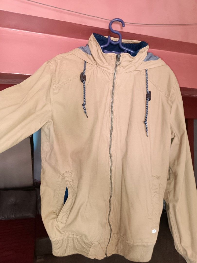 Springfield Tan Hooded Jacket Size M (Category: Coats, Jackets and Outerwear) located in Imus. Submitted by melgibsong24 (Listing ID 1465763906, Image 3). Description: - Brand: Springfield - Color: Tan with dark blue interior lining - Size: M (175/100A) - Design: Zip-up front with branded pull, metal logo tag, and adjustable collar drawstrings with toggles - Comfort: Ribbed cuffs and hem to block the wind - Condition: Excellent for everyday casua