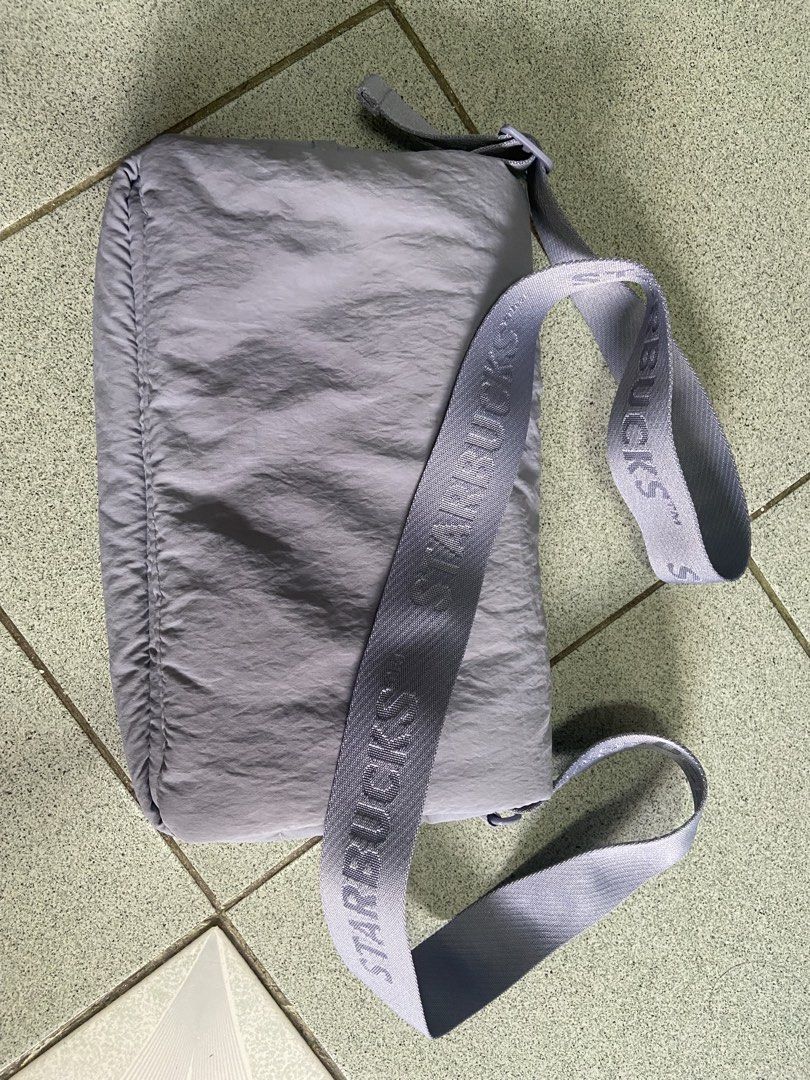 starbucks pufflet sling bag (Category: Cross-body Bags) located in Silang. Submitted by Apple_Mac07 (Listing ID 1465832561, Image 1). Description: - Authentic Starbucks quilted crossbody bag in a versatile soft grey shade (color: periwinkle) - Durable padded fabric body with a secure magnetic closure flap - Thick, adjustable shoulder strap featuring the iconic Starbucks wordmark - Interior includes a handy open slip pocket and official brand tag 