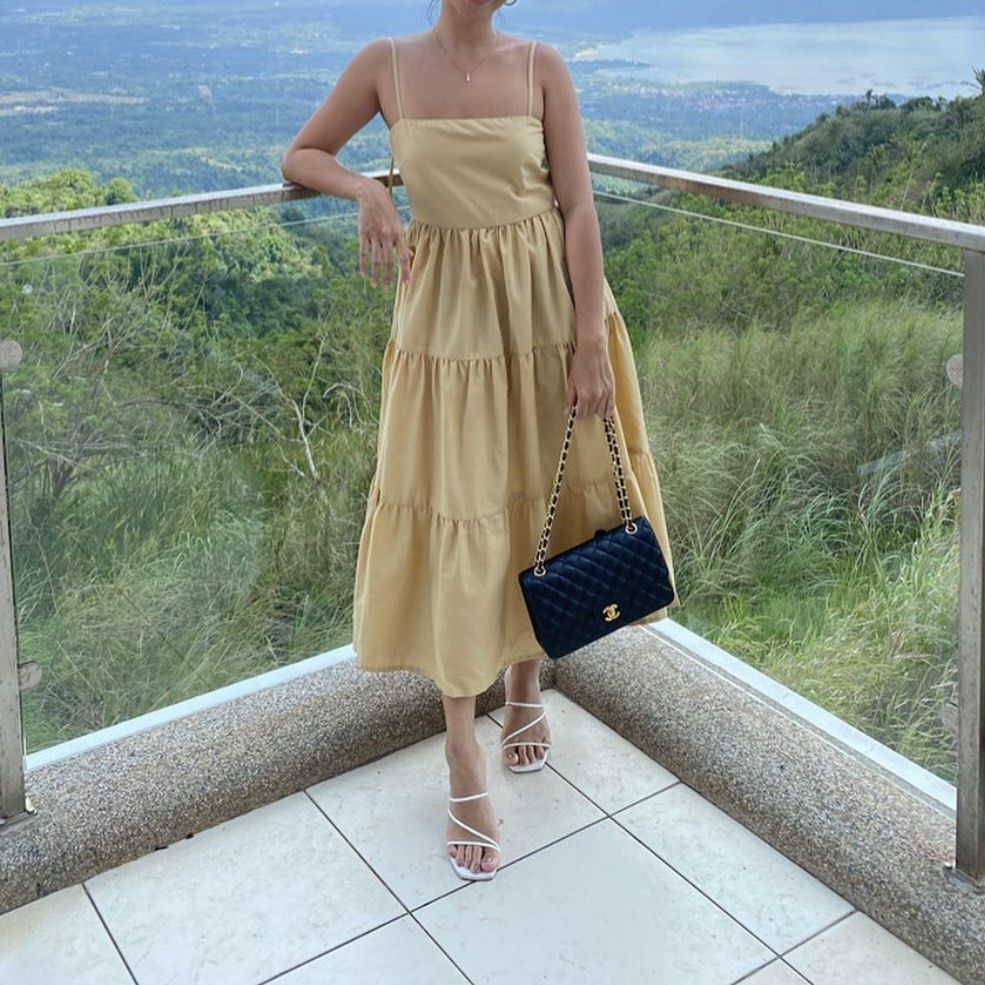 Studio Caca Beige Tiered Midi Dress (S) (Category: Dresses) located in San Juan City. Submitted by jcmsells (Listing ID 1465841173, Image 2). Description: - Color: Neutral beige - Neckline: Square neckline with thin spaghetti straps - Silhouette: Fitted bodice with a 3-tiered gathered midi skirt - Fabric: Smooth finish with a slight structure - Versatility: Easily styled for casual days out, vacations, or dressed up with heels - Condition: Excell