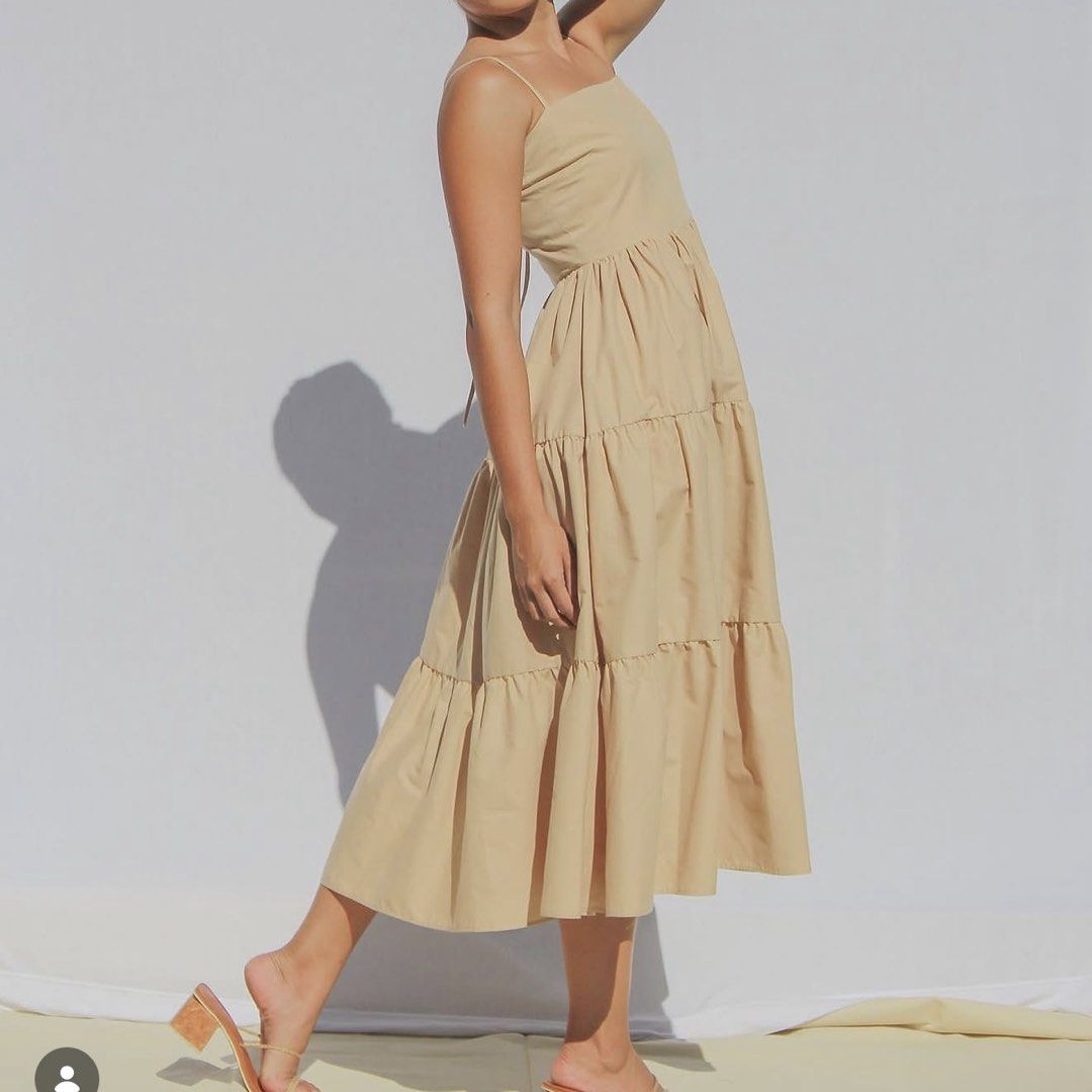 Studio Caca Beige Tiered Midi Dress (S) (Category: Dresses) located in San Juan City. Submitted by jcmsells (Listing ID 1465841173, Image 1). Description: - Color: Neutral beige - Neckline: Square neckline with thin spaghetti straps - Silhouette: Fitted bodice with a 3-tiered gathered midi skirt - Fabric: Smooth finish with a slight structure - Versatility: Easily styled for casual days out, vacations, or dressed up with heels - Condition: Excell