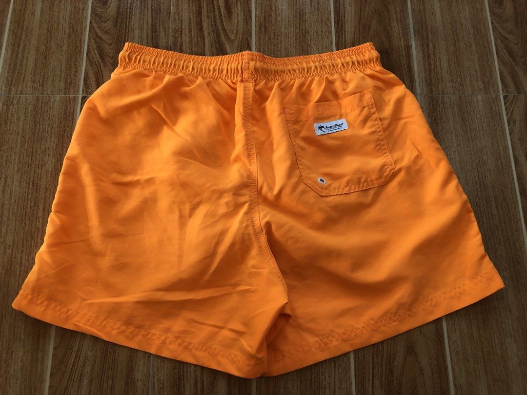 Sunset Beach Orange Swim Shorts (Category: Swim Trunks & Board Shorts) located in Tarlac. Submitted by f8njcgvfqy90581 (Listing ID 1465897027, Image 2). Description: - Brand: Sunset Beach - Color: Bright orange with black drawstring and white aglets - Features: Built-in white mesh lining, single back pocket with flap and brand label, subtle palm tree embroidery - Length: 15 inches - Ideal for: Swimming, pool days, and beach getaways.