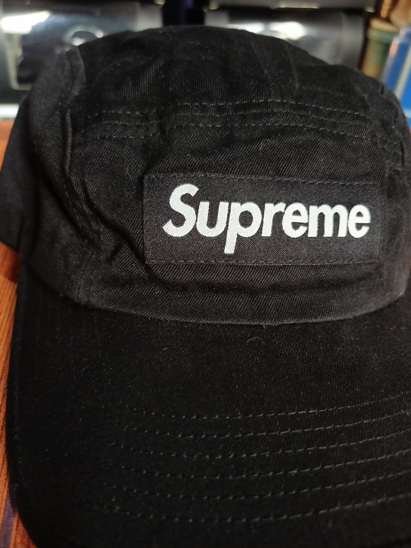 Supreme Camp Cap (Category: Caps & Hats) located in Abucay. Submitted by vcc.plug (Listing ID 1465779479, Image 2). Description: - Brand: Supreme - Color: Classic Black - Design: 5-panel camp cap with iconic box logo on front - Details: Metal side eyelets for breathability and sturdy brim stitching - Closure: Adjustable leather strapback with metal buckle - Condition: Brand new / Excellent daily streetwear accessory.