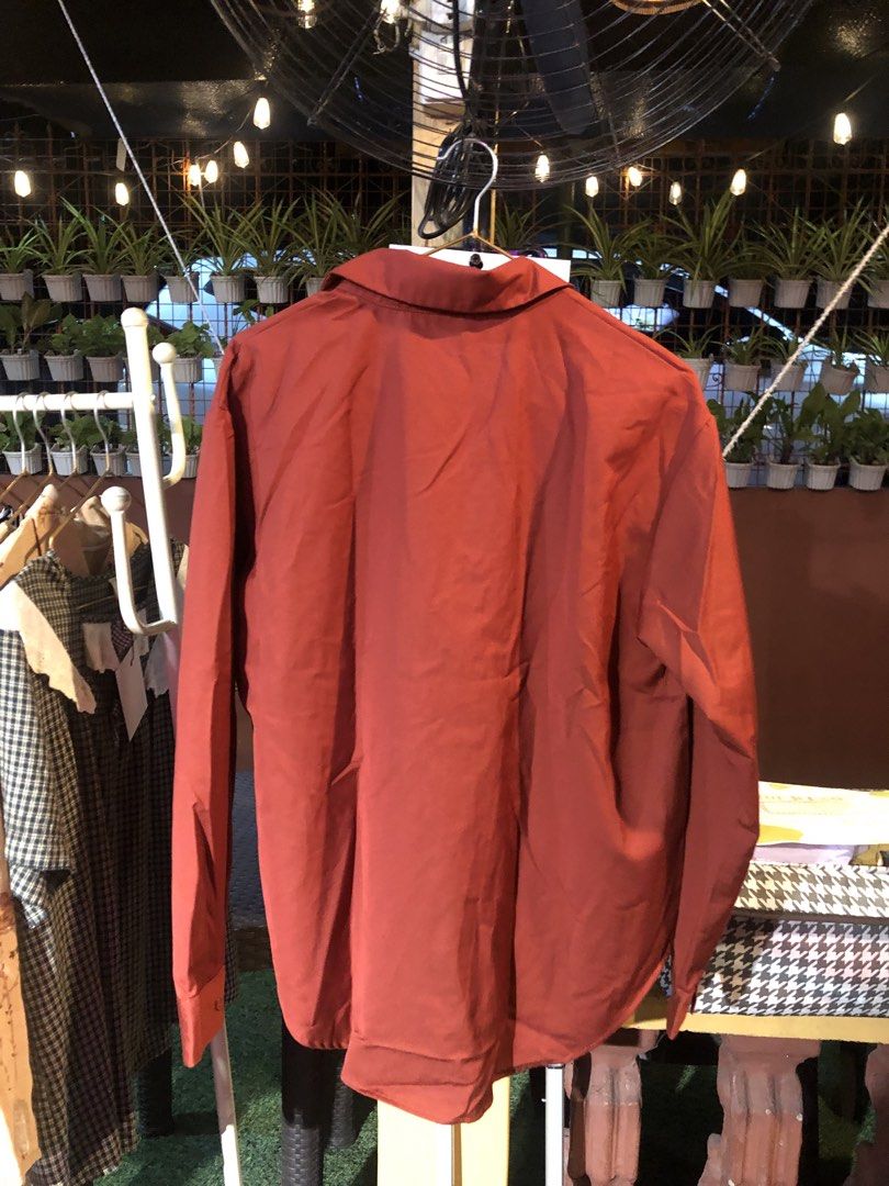 Suyan Brick Red Long Sleeve Button-Up Shirt (Category: Longsleeves) located in Cauayan City . Submitted by wholly.craaaft (Listing ID 1465876845, Image 3). Description: - Brand: Suyan - Color: Brick red - Fit: Relaxed fit with a curved hem - Details: Long sleeves, classic collar, single front pocket, standard button-down closure - Material: Soft and comfortable - Versatile basic piece, great for layering or wearing solo with jeans or slacks.