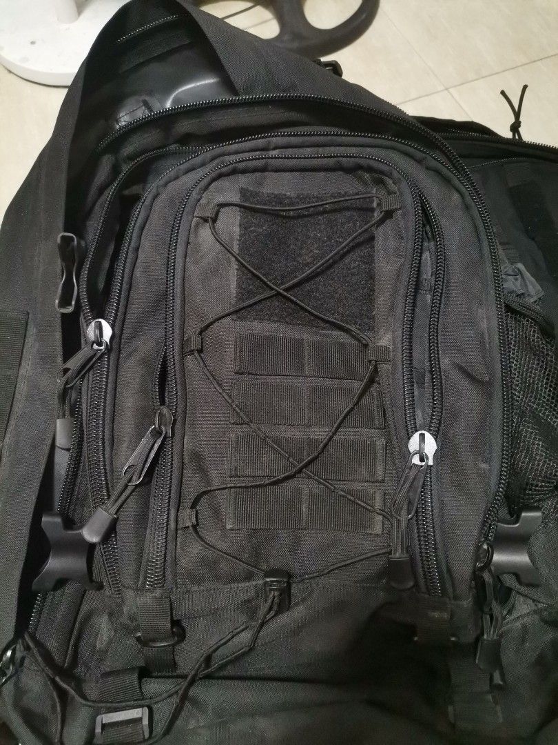 Tactical black backpack multi compartment heavy duty (Category: Backpacks) located in Makati City. Submitted by kookybearsstuff (Listing ID 1465818118, Image 1). Description: - Color: Black - Material: Sturdy, heavy-duty build - Compartments: Multiple zipped compartments and inner pockets - Front Features: Bungee cord webbing and Velcro patch area - Strap Details: Includes a small detachable pouch and D-rings - Condition: Zippers work perfectly, 