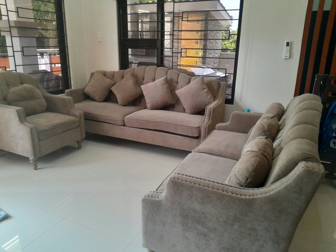 Taupe Upholstered Sofa Set with Pillows (Category: Sofas) located in Batangas. Submitted by meloisaquijano (Listing ID 1465866055, Image 2). Description: - Complete matching living room set: 1 large sofa, 1 mid-sized sofa, and 1 armchair - Elegant taupe soft fabric with classic tufted backrests - Stylish decorative nailhead trim along the arms - Includes matching and dark brown accent throw pillows - Versatile neutral color complements most home 